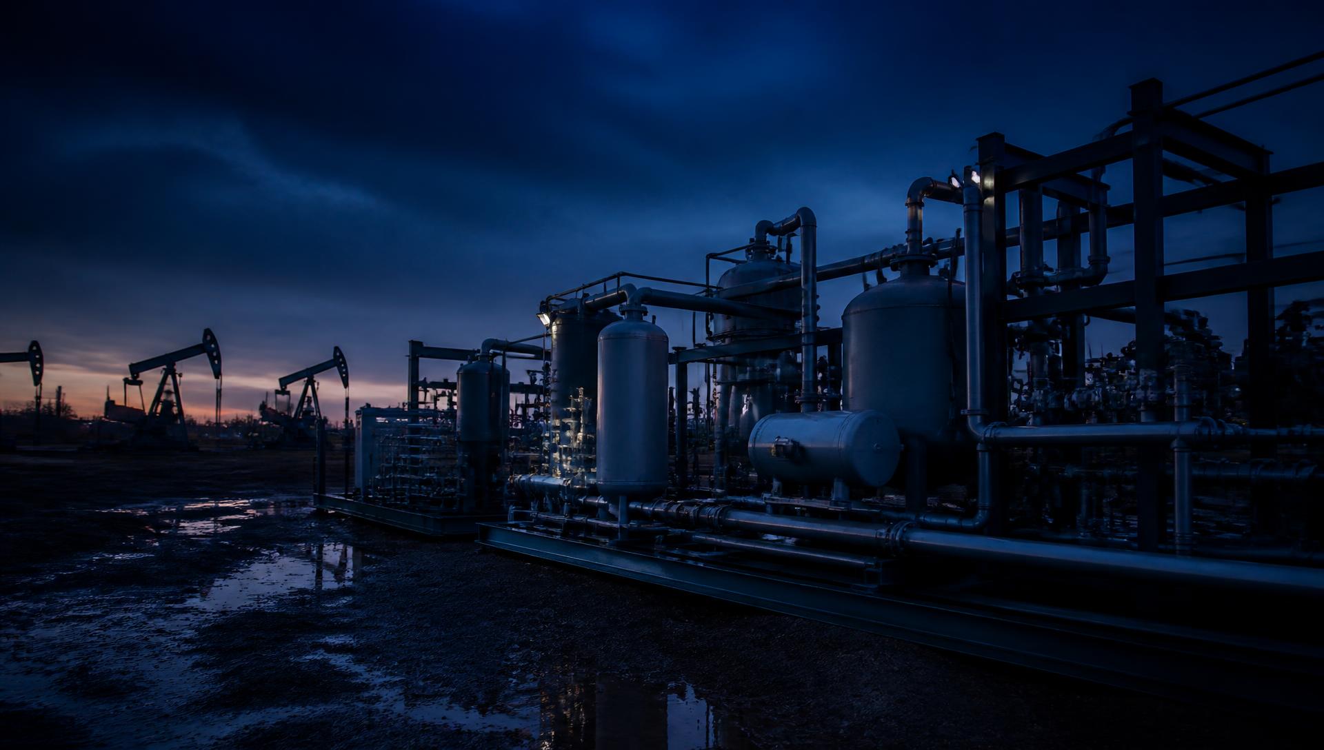 Modular produced-water treatment skids at an oilfield site at dusk